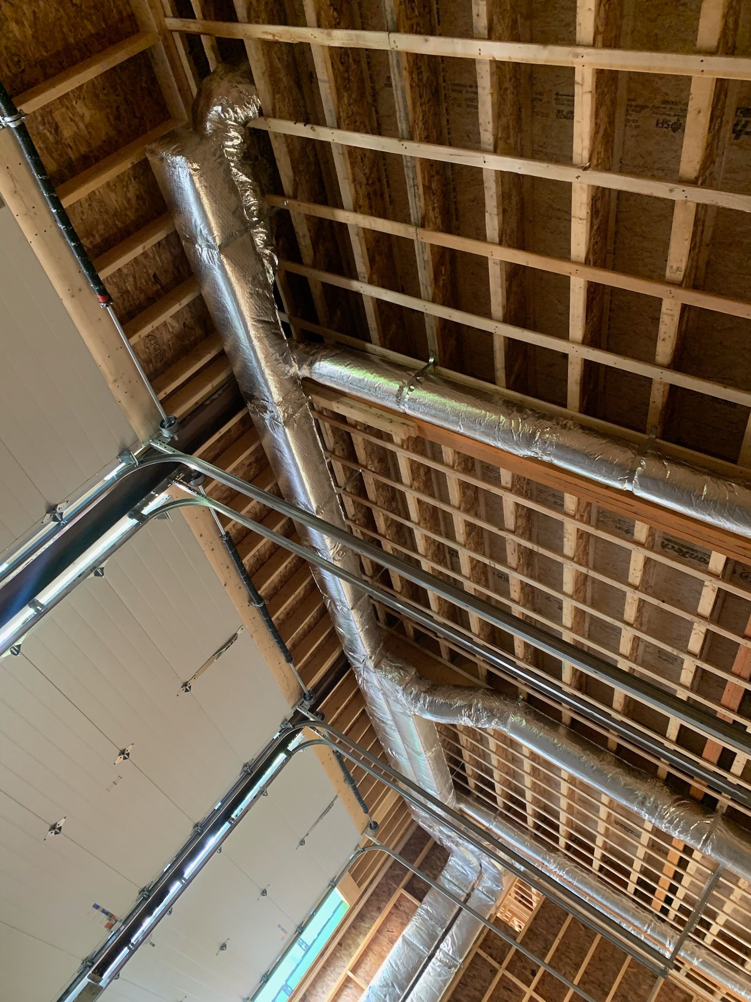 Ceiling with exposed wooden beams, silver ductwork, and insulation.