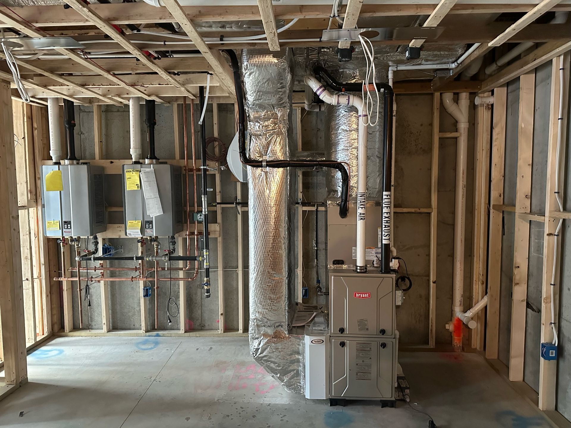 HVAC system installation in a new construction room. Includes furnace, water heaters, ductwork, and pipes.