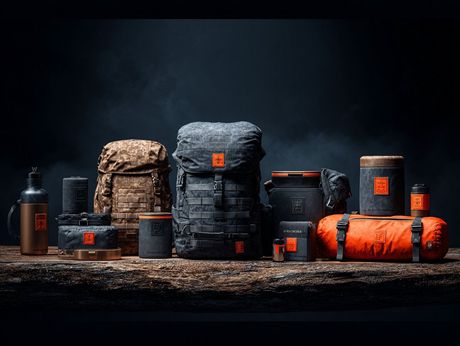 Collection of outdoor gear, in various sizes, colors, and shapes. Dark setting with a wooden surface.