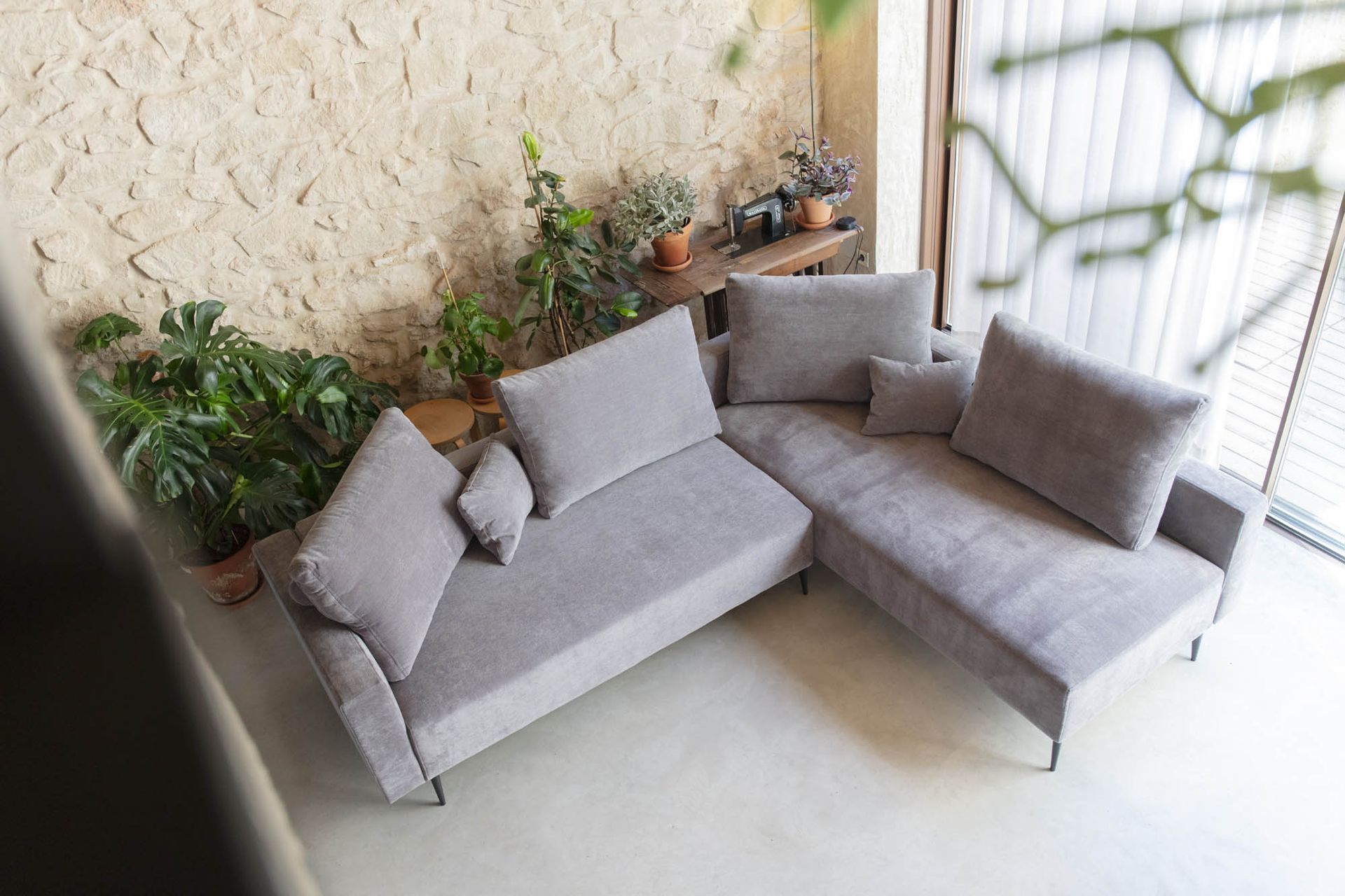 Un grande divano componibile Moonap è posizionato in un soggiorno, accanto a una finestra.