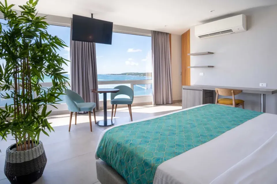 Habitación con balcón y vista al mar en Hotel Samawi San Andrés, alojamiento perfecto para parejas que buscan relax y romance.
