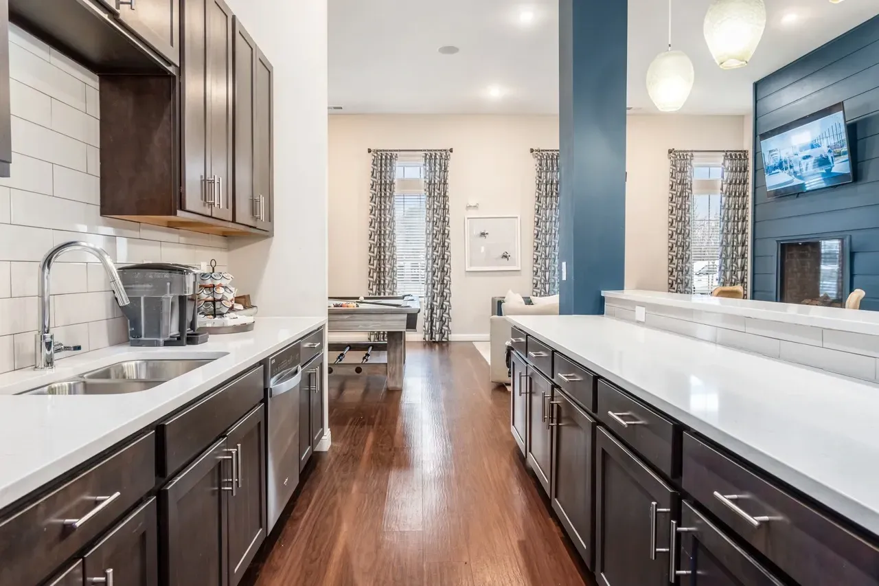 Modern kitchen with dark cabinets, stainless steel appliances, and a double sink.