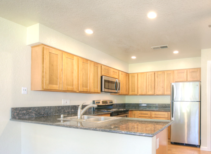 Kitchen with wood cabinets, granite countertops, stainless steel appliances, and recessed lighting.