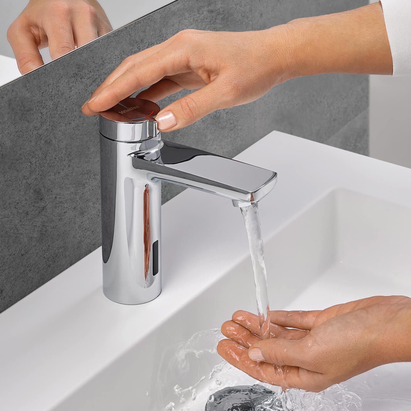 Eine Person wäscht ihre Hände in einem Waschbecken im Badezimmer