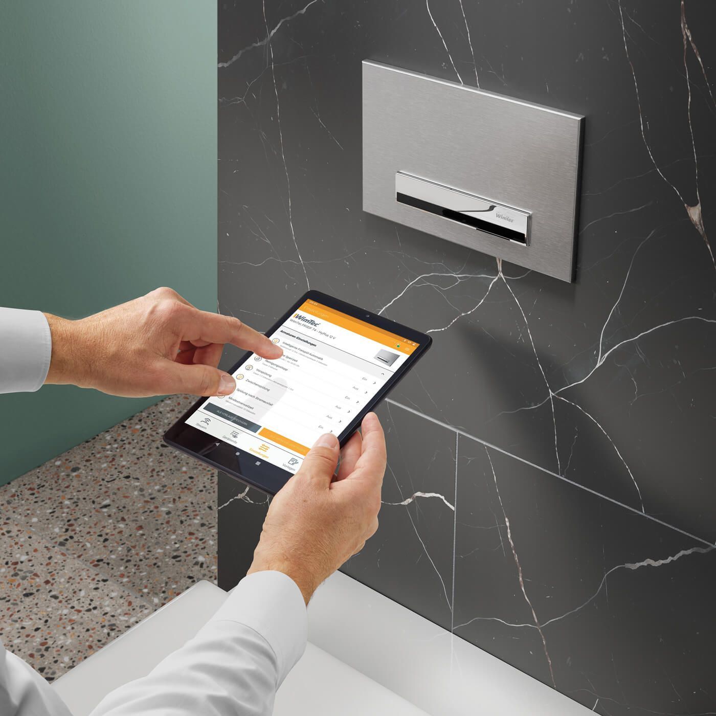 Eine Person benutzt ein Tablet in einem Badezimmer.