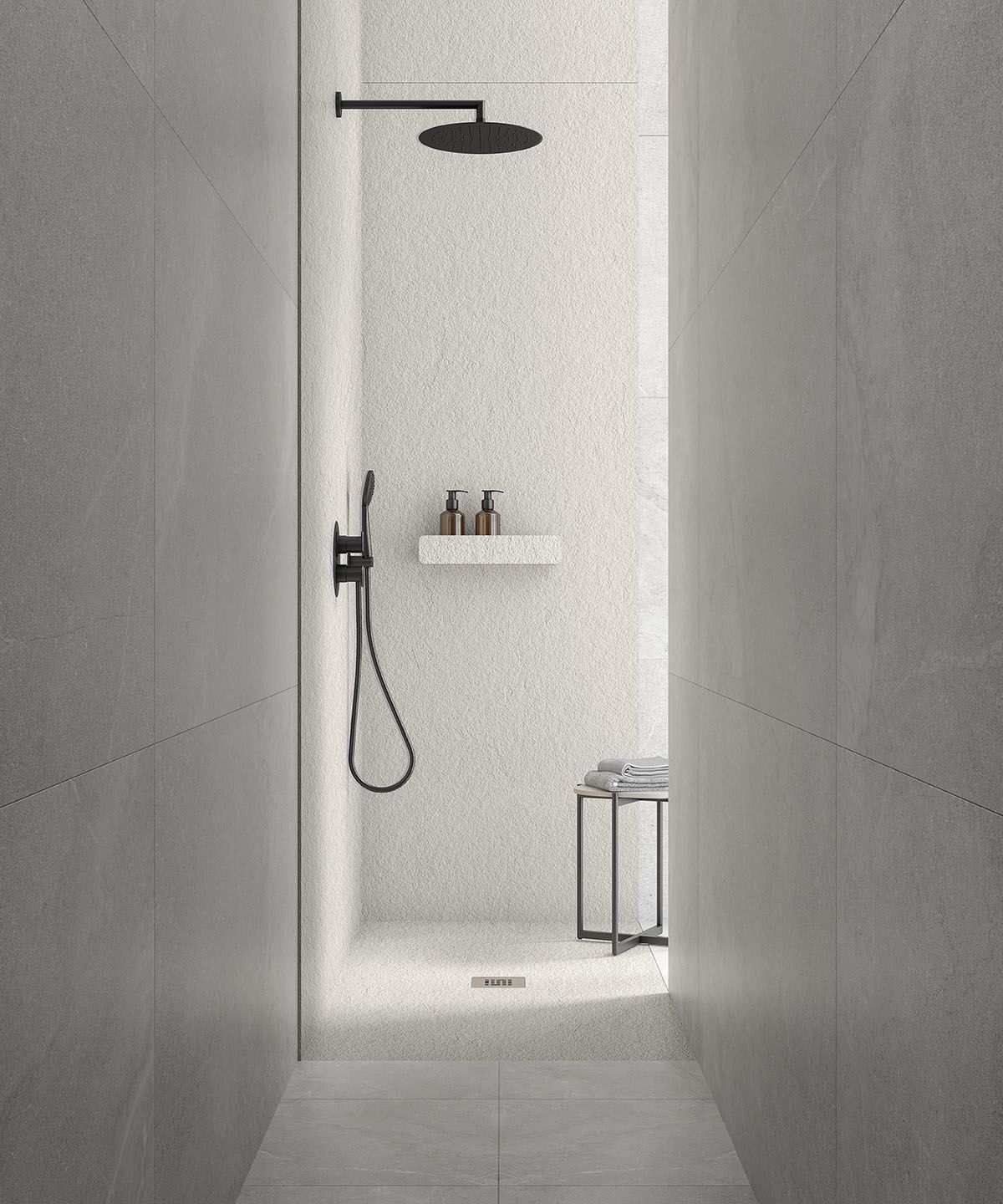 Ein Badezimmer mit ebenerdiger Dusche und schwarzem Duschkopf.