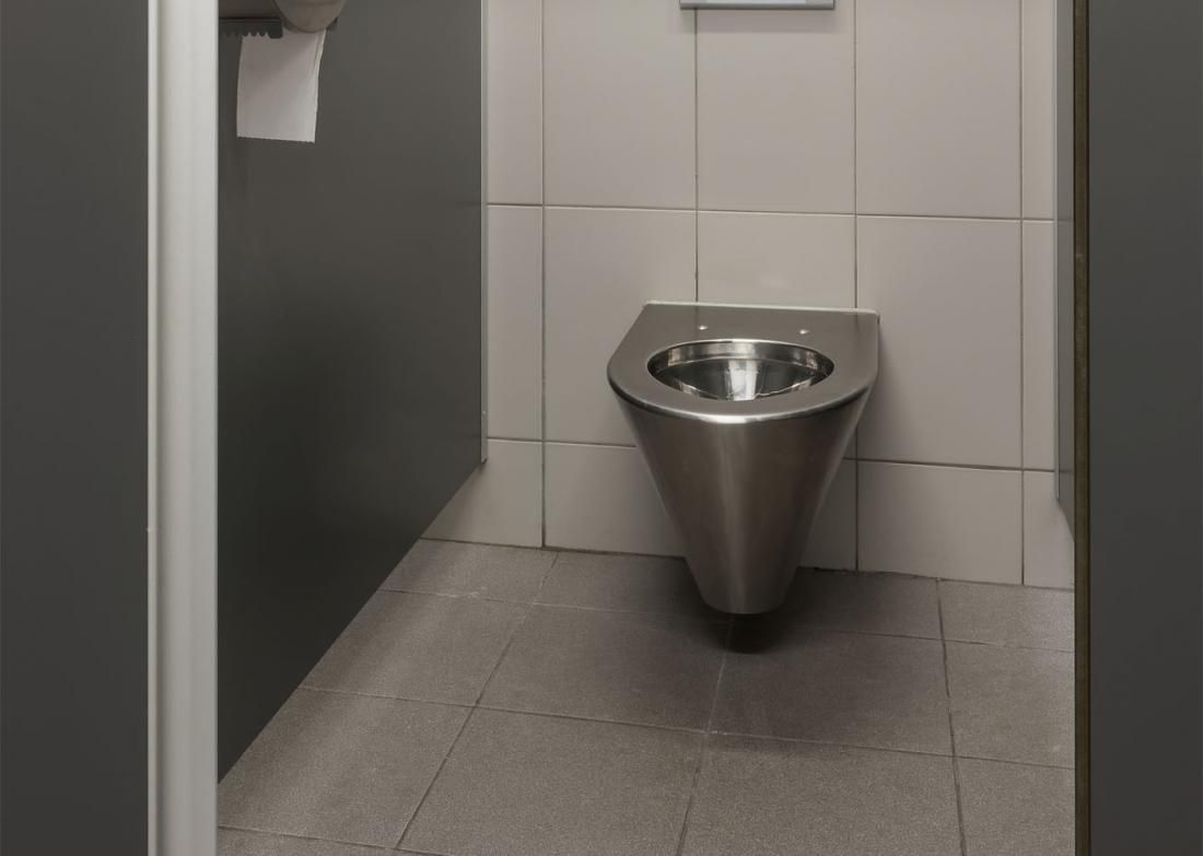In einer öffentlichen Toilette hängt eine Toilette aus Edelstahl an der Wand.