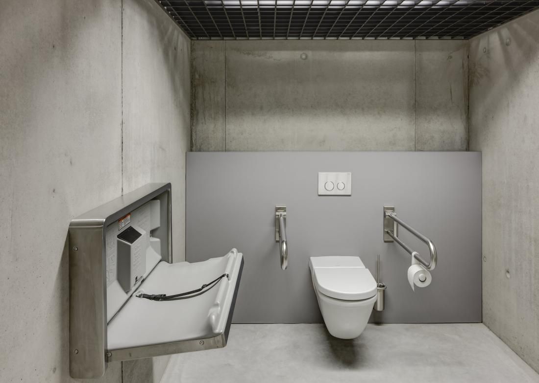 Ein Badezimmer mit Toilette und Wickeltisch.