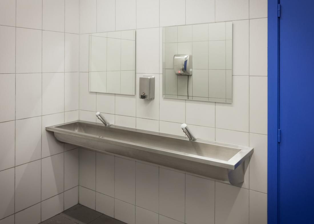 Ein Badezimmer mit einem Waschbecken aus Edelstahl und zwei Spiegeln.