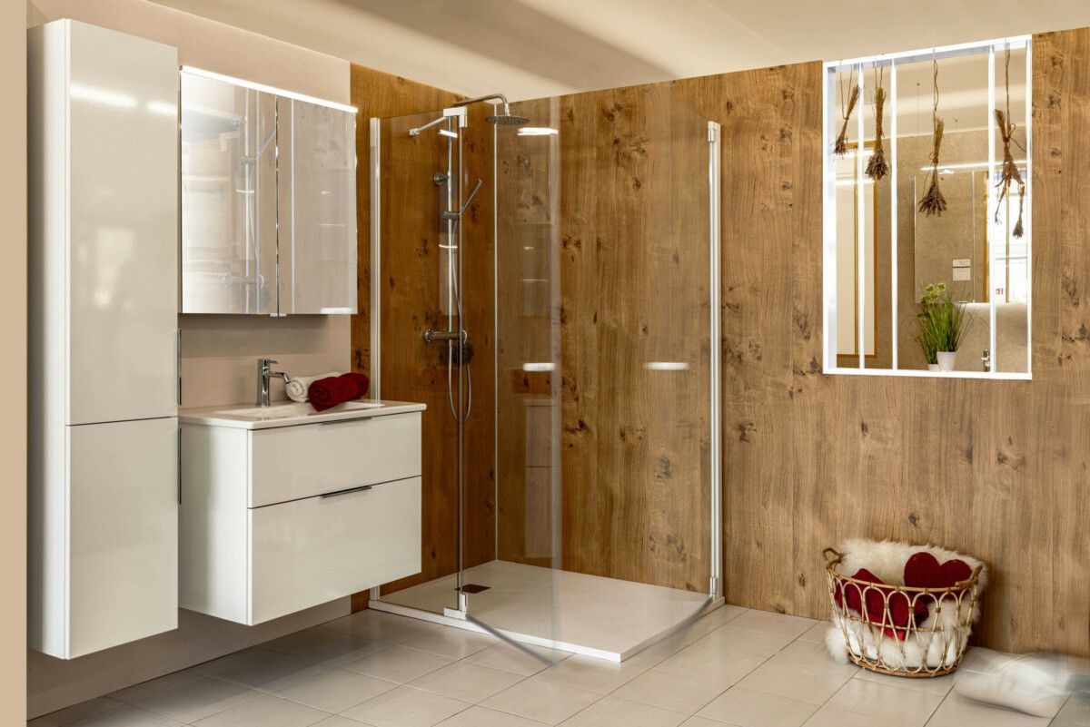 Ein Badezimmer mit Waschbecken, Schränken, Spiegeln und begehbarer Dusche.