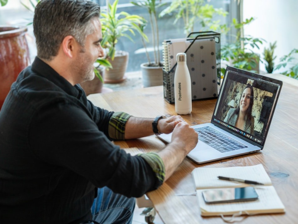 Ein Mann sitzt an einem Schreibtisch und benutzt einen Laptop.