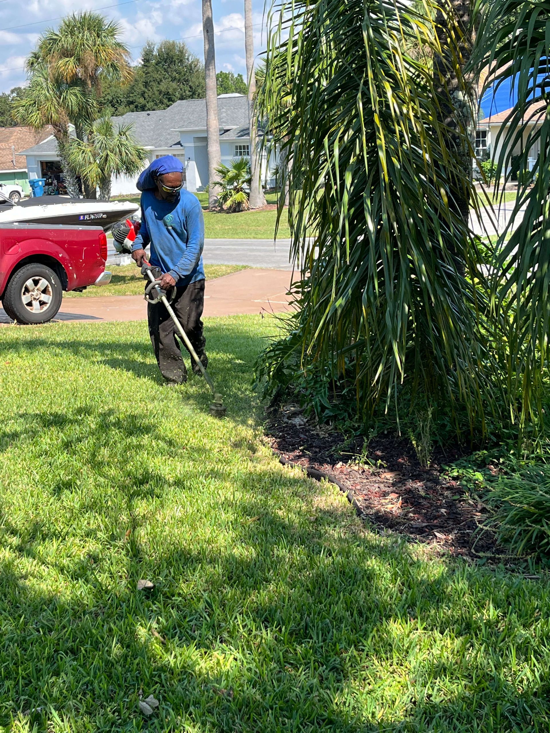 A man is cutting grass in a yard with a lawn mower.