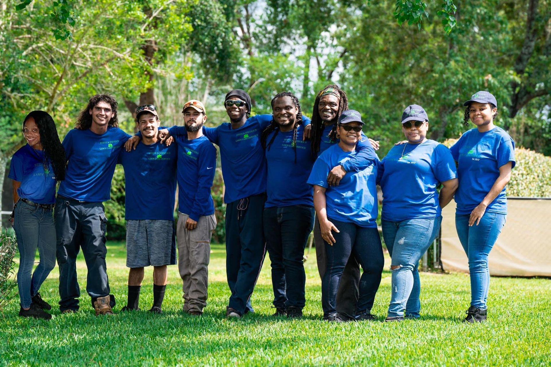 A group of people are posing for a picture in a park.