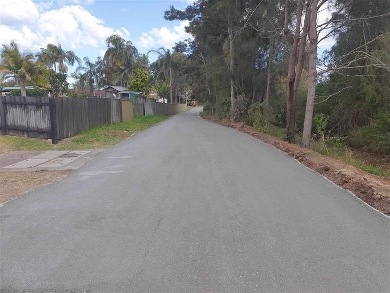 Empty Newly Paved Road Bordered by a Wooden Fence — Ace Clearing & Mulching In Old Bar, NSW