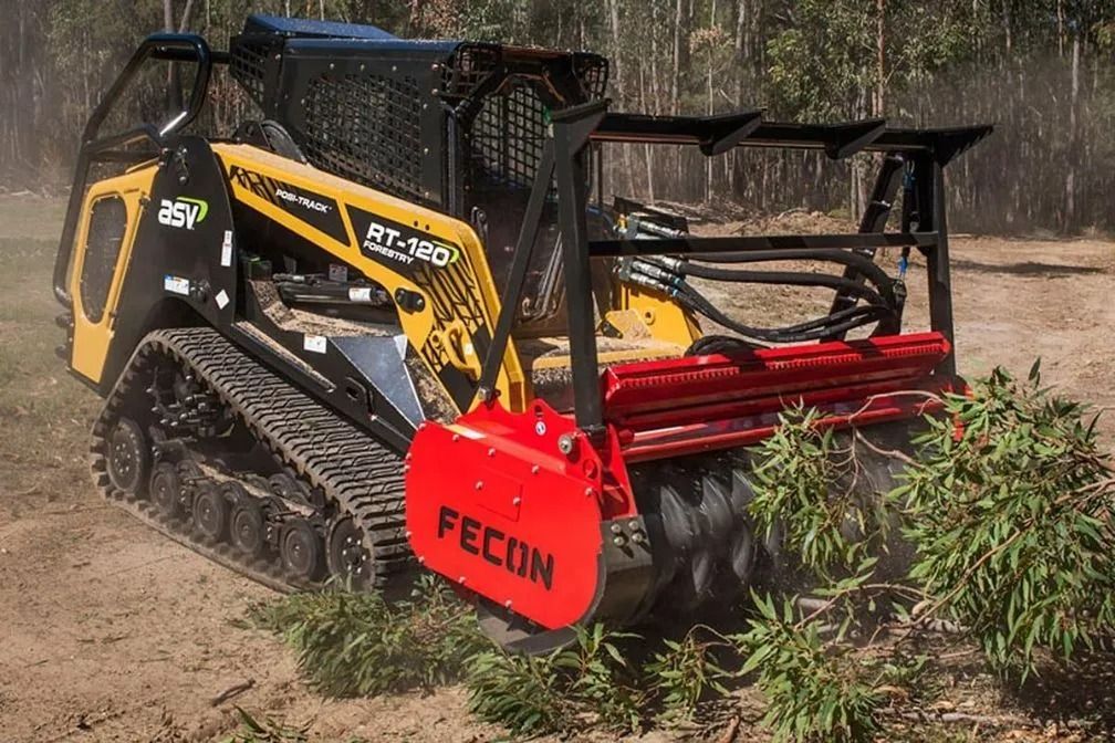 Yellow and Black Tracked Skid Steer  Mulching Vegetation in a Wooded Area — Ace Clearing & Mulching In Old Bar, NSW