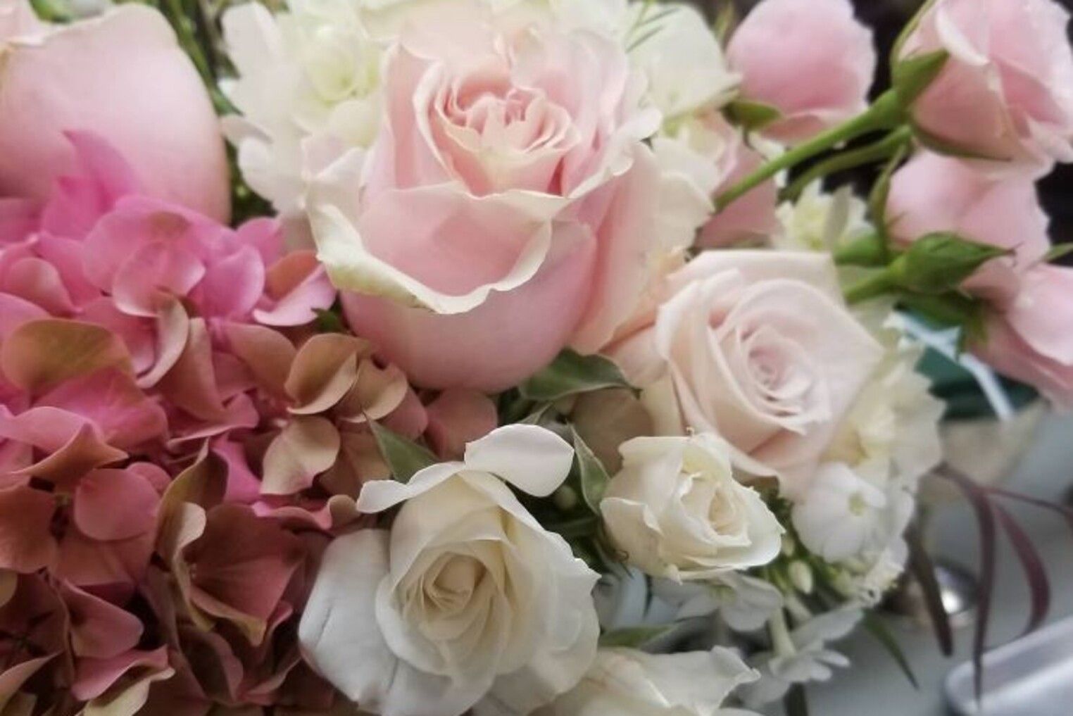 A close up of a bouquet of pink and white flowers on a table.