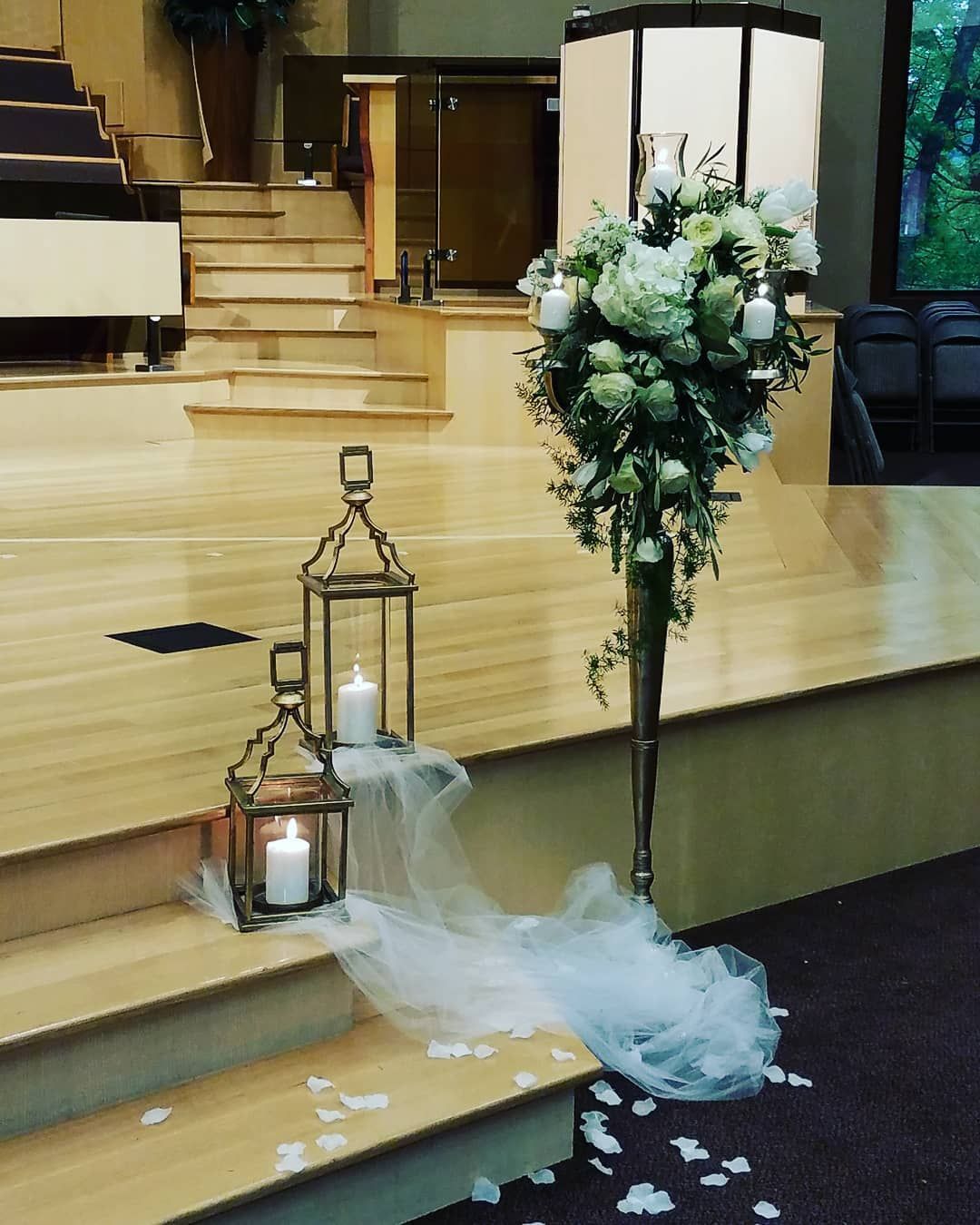 A wooden stage with candles and flowers on it