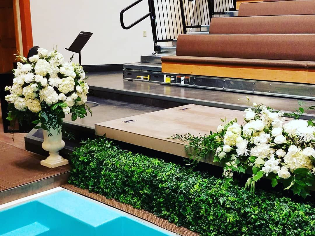 A swimming pool is surrounded by flowers in a church.