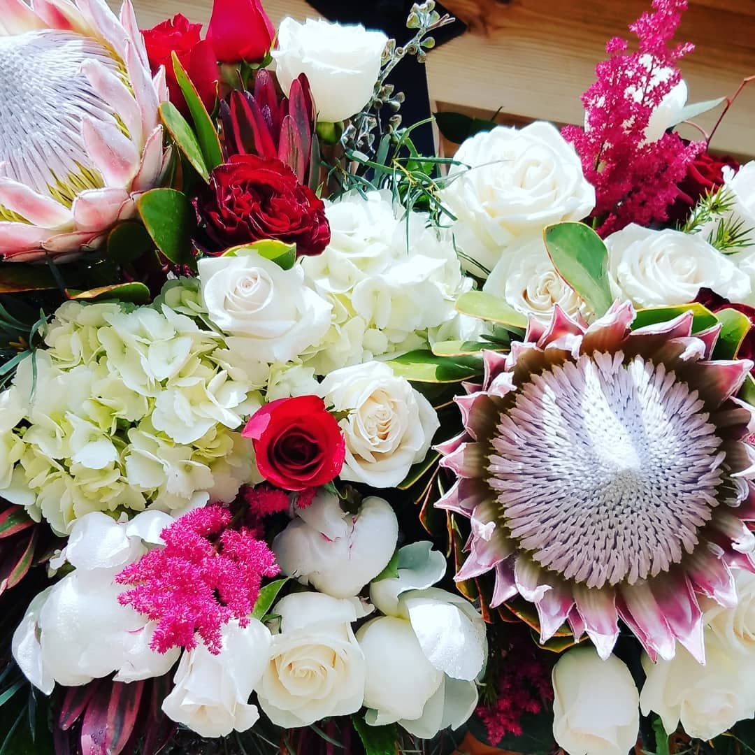 A bunch of different types of flowers are sitting on a table.