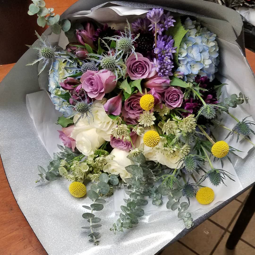 A bouquet of flowers is sitting on a wooden table.