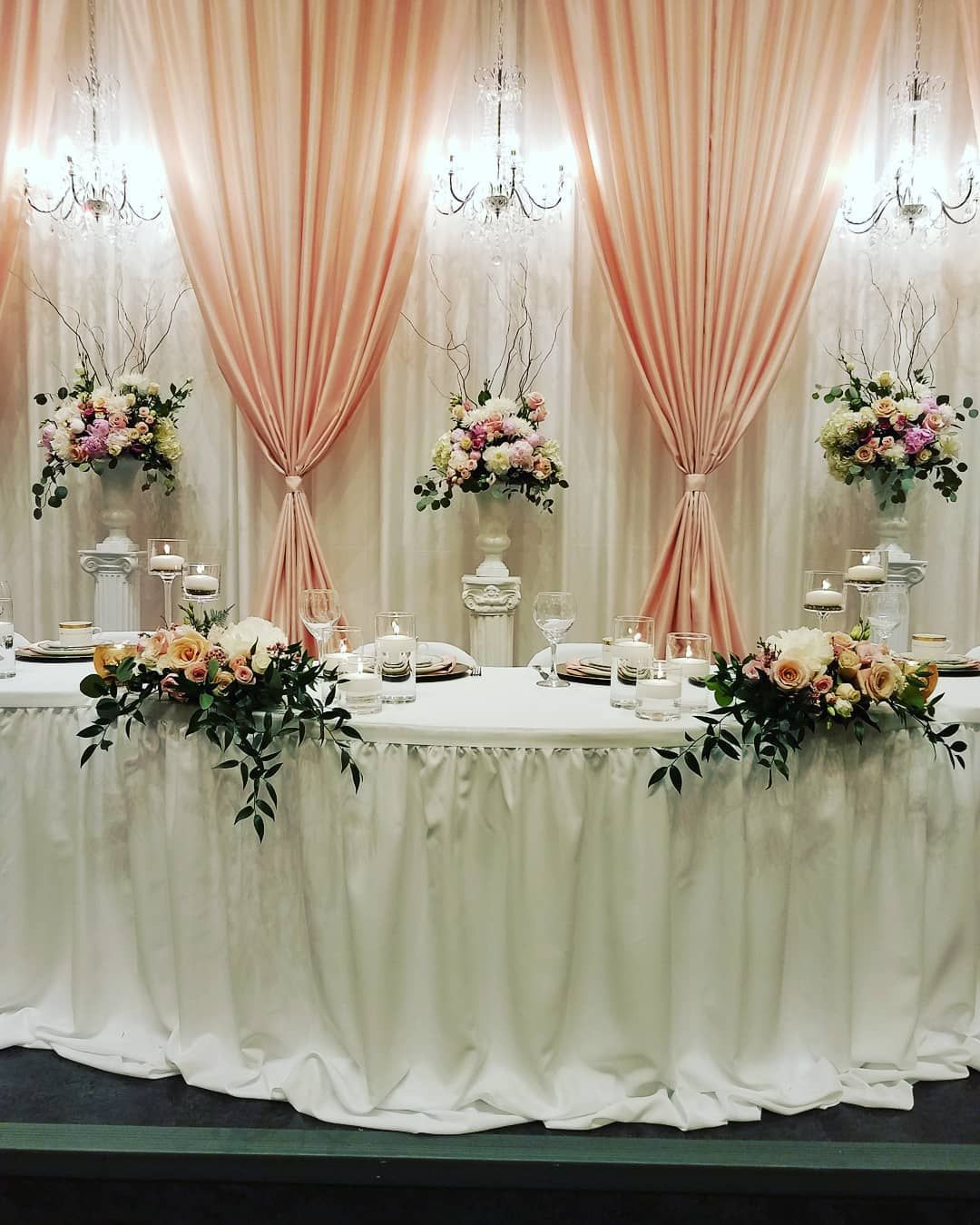 A long table with flowers and candles on it.
