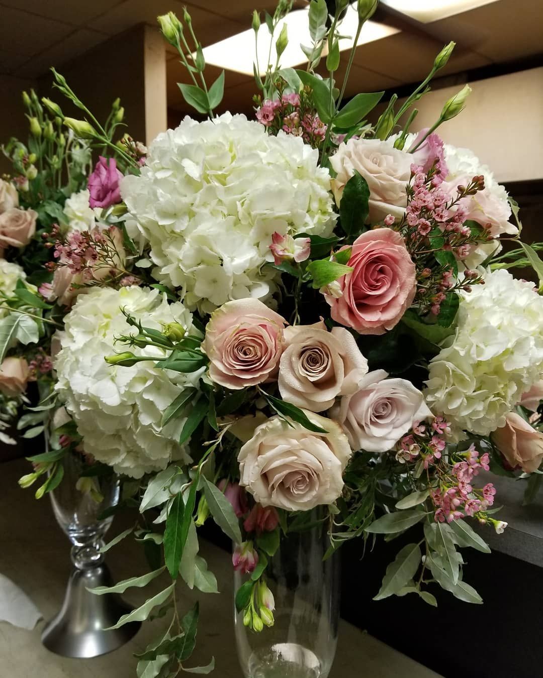 A vase filled with pink and white flowers is sitting on a table.