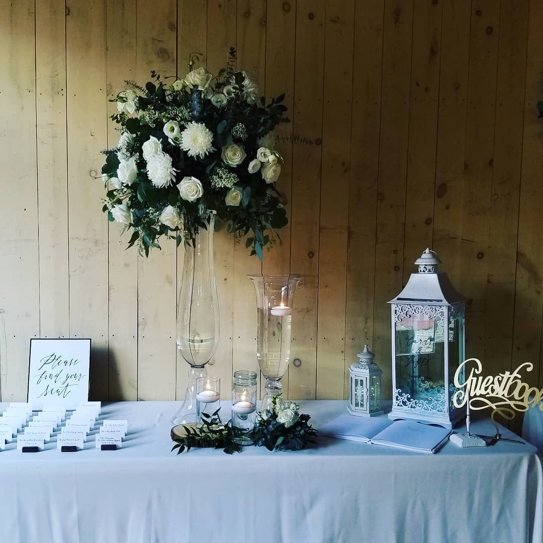 A table with a vase of flowers and candles on it