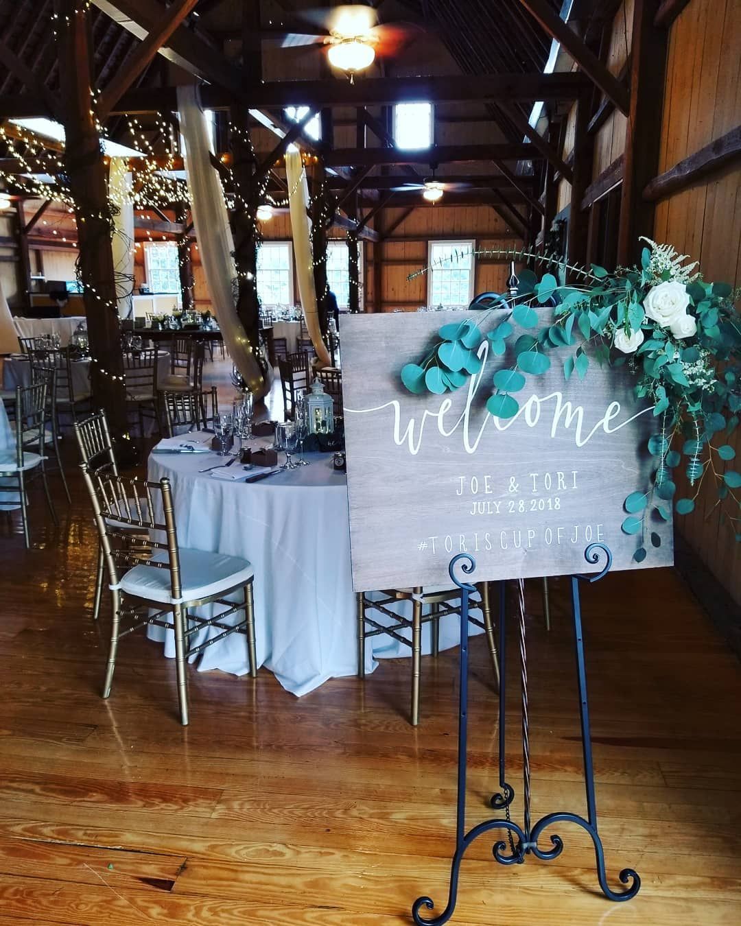 A welcome sign is sitting in a room with tables and chairs.