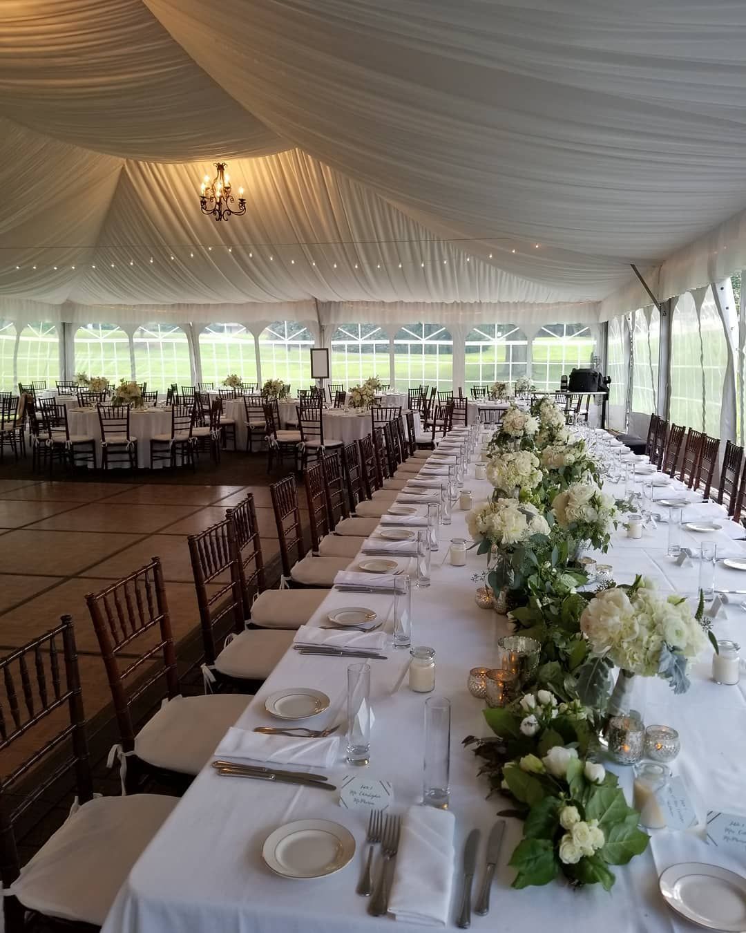 A long table with flowers on it in a large room