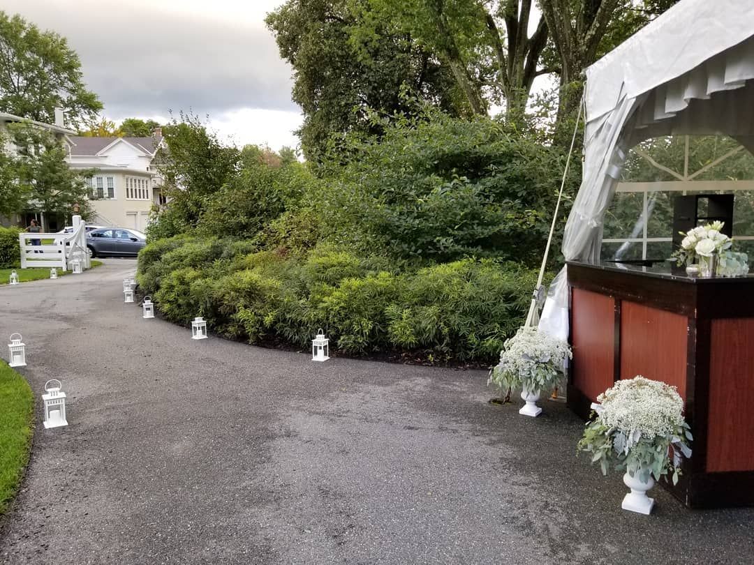 A row of lanterns are lined up on the side of a road next to a tent.