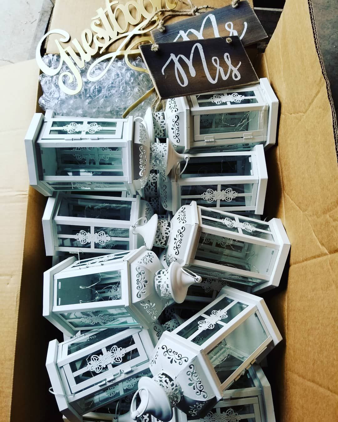A box filled with white lanterns and a sign that says mrs.
