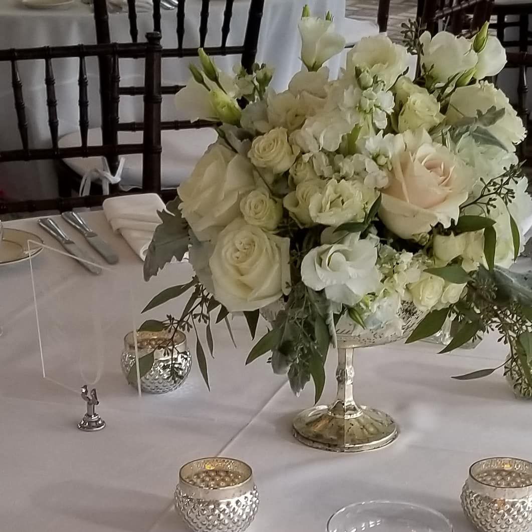 A table with a vase of white flowers on it
