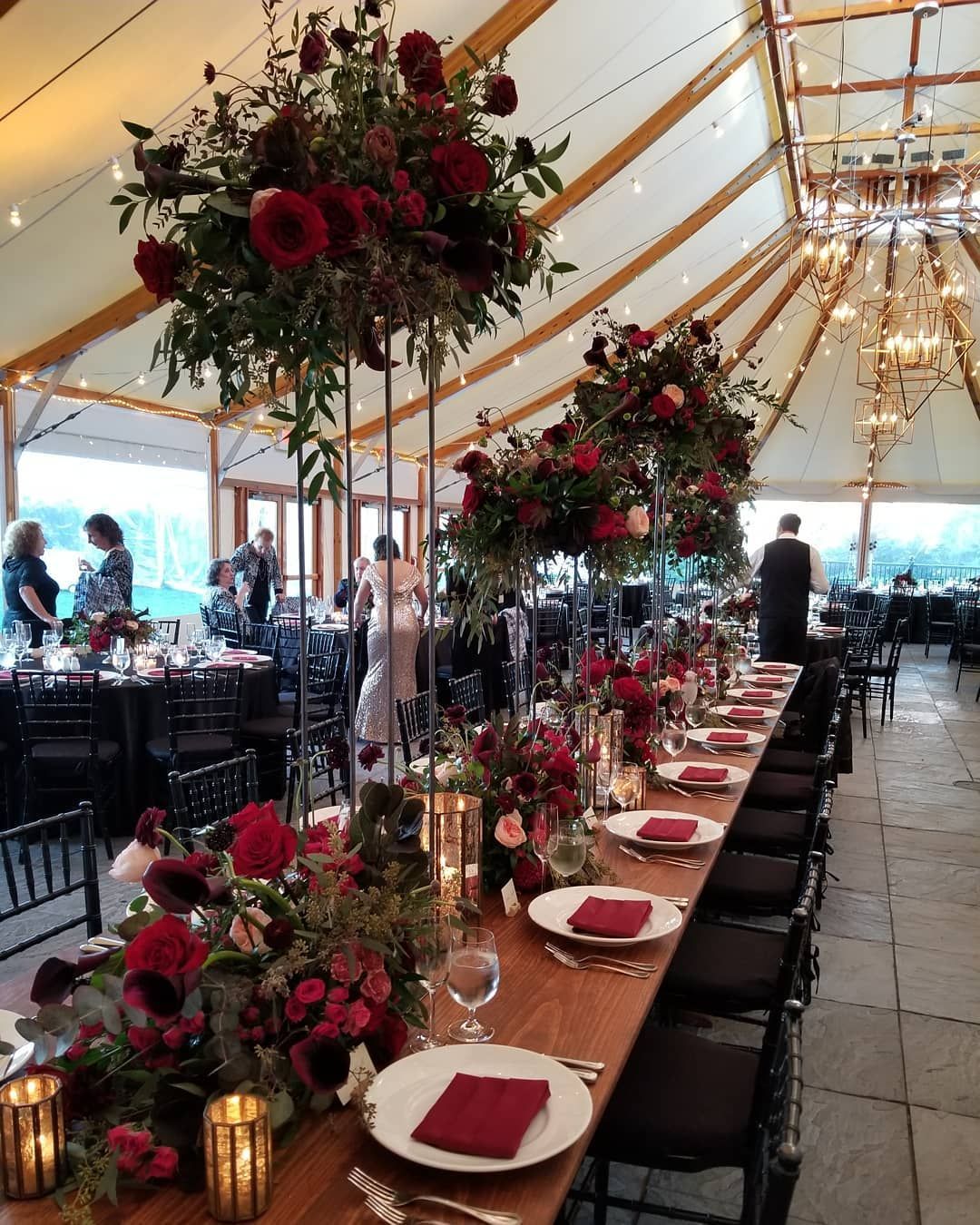 A long table with plates , candles , and flowers on it.