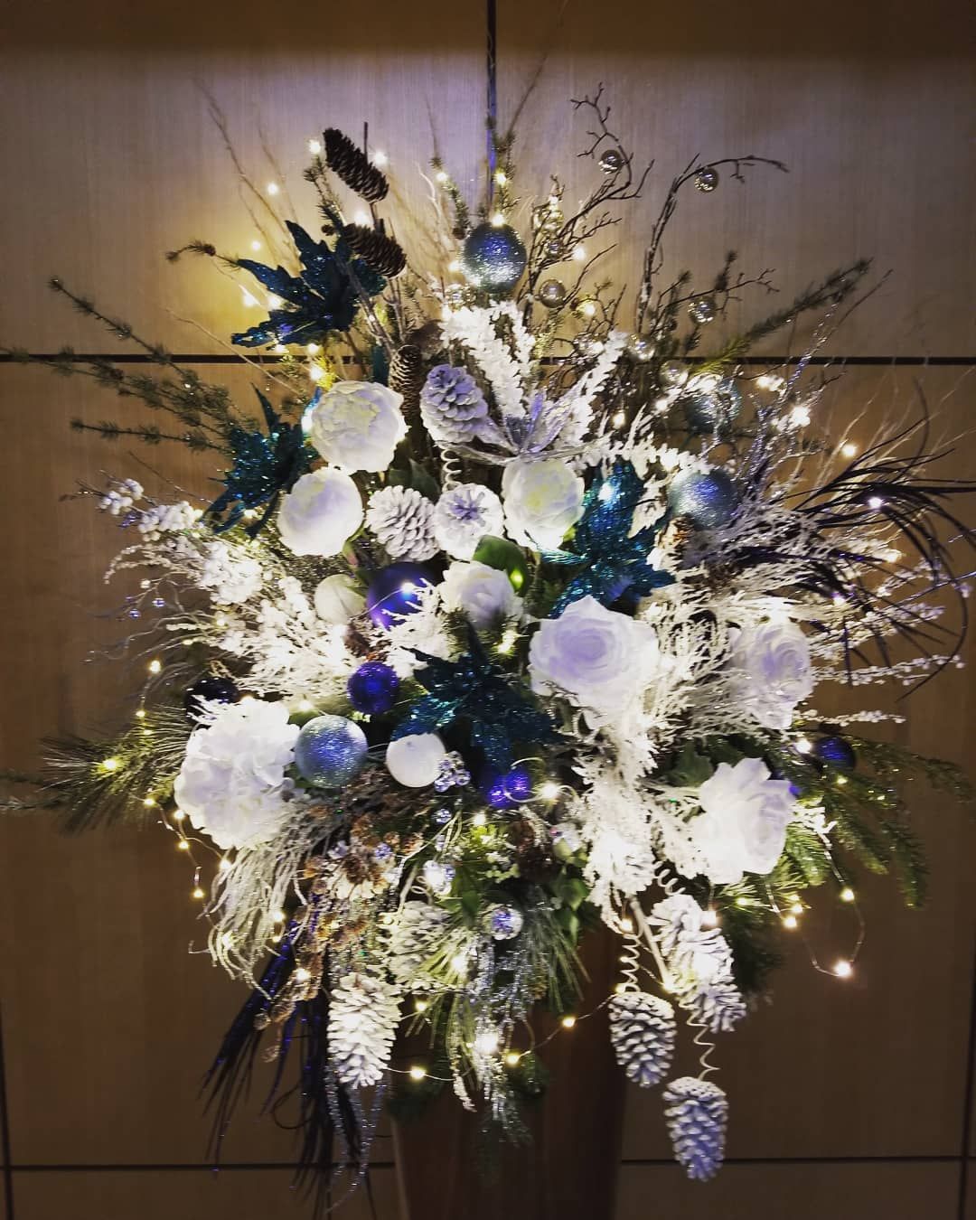 A vase filled with flowers and lights is sitting on a table.