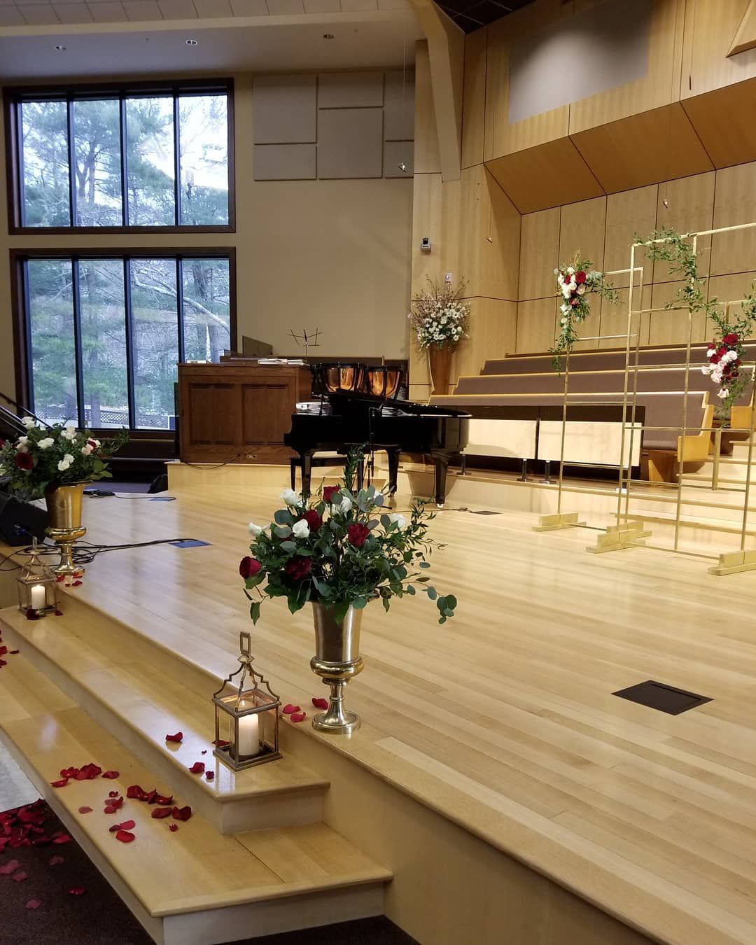 A large room with a piano and flowers on the floor