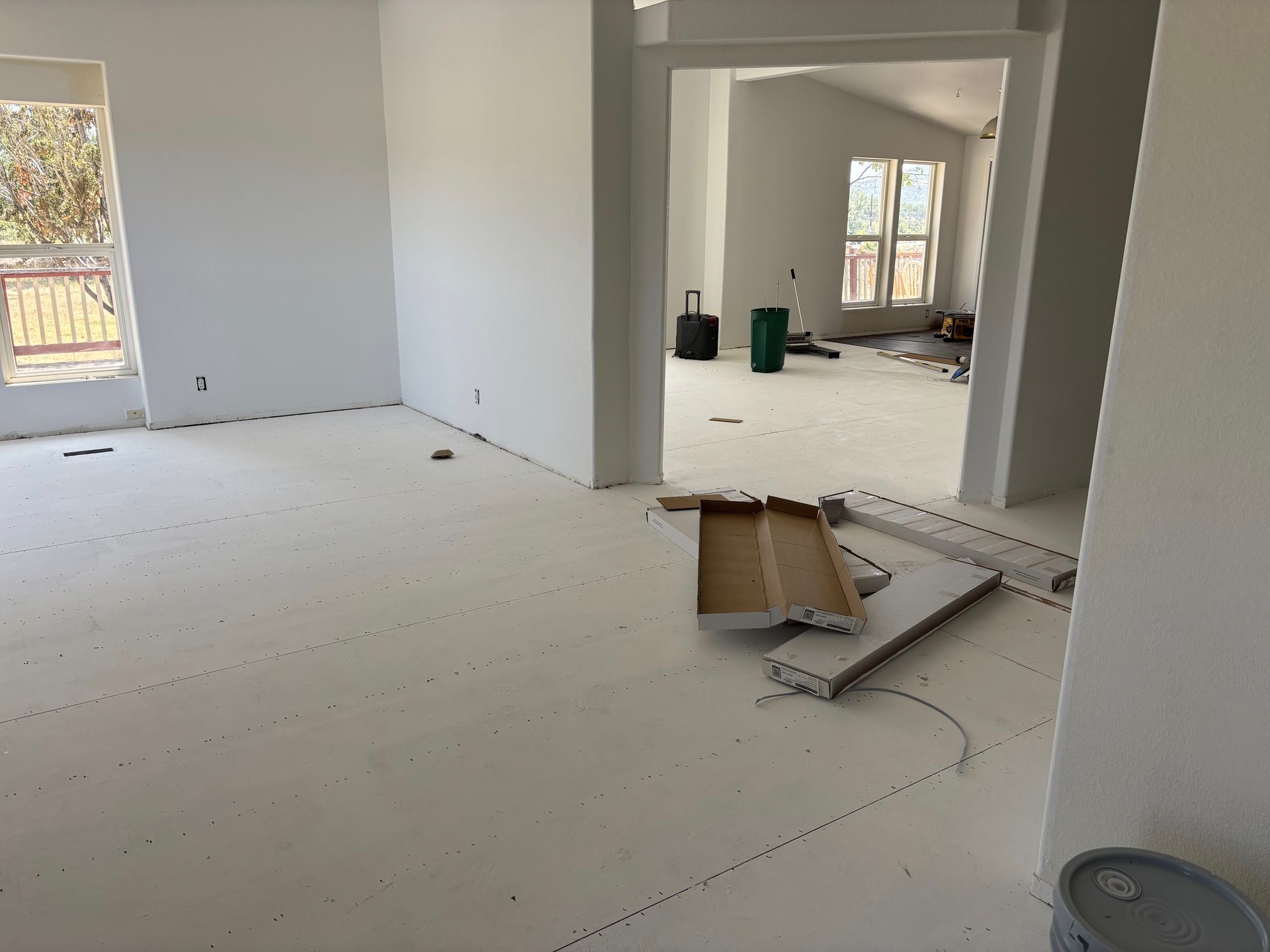 Interior of a house under construction, white walls, bare floors, open doorways.
