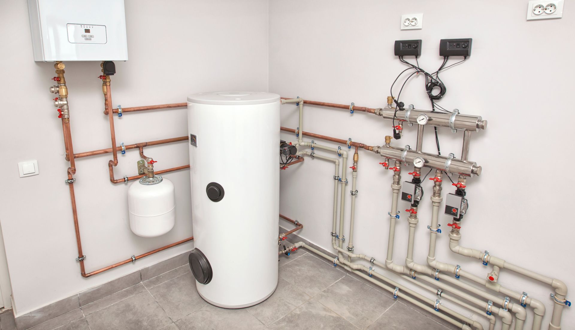 A cluttered boiler room with various equipment, including a boiler, heater, pipes, expansion tank, and more.
