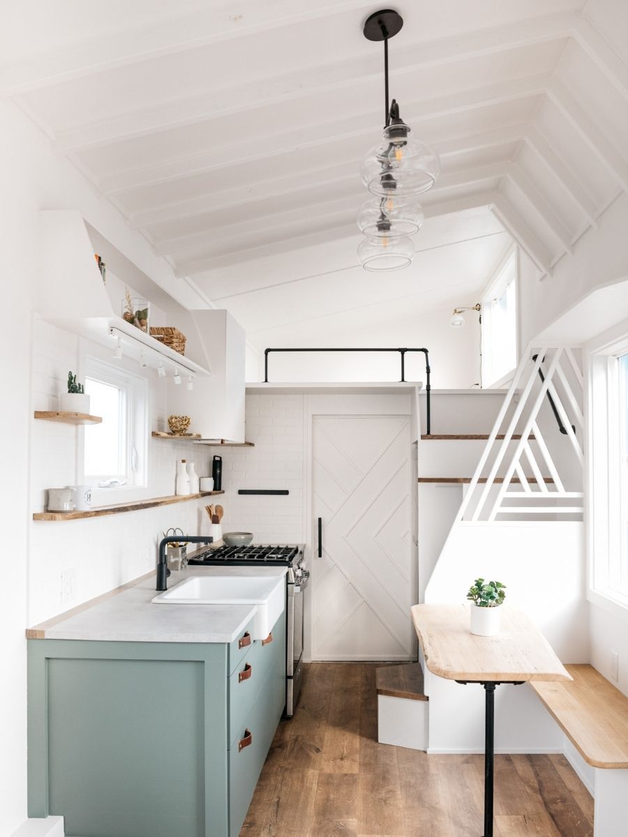 A kitchen with a sink , stove , and table.