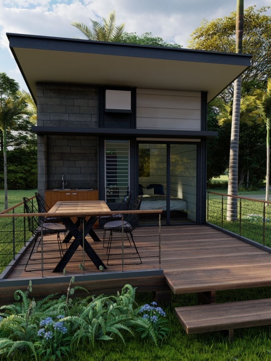 A small house with a table and chairs on the deck.