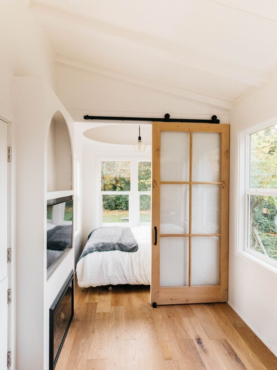 A bedroom with a bed and a sliding barn door