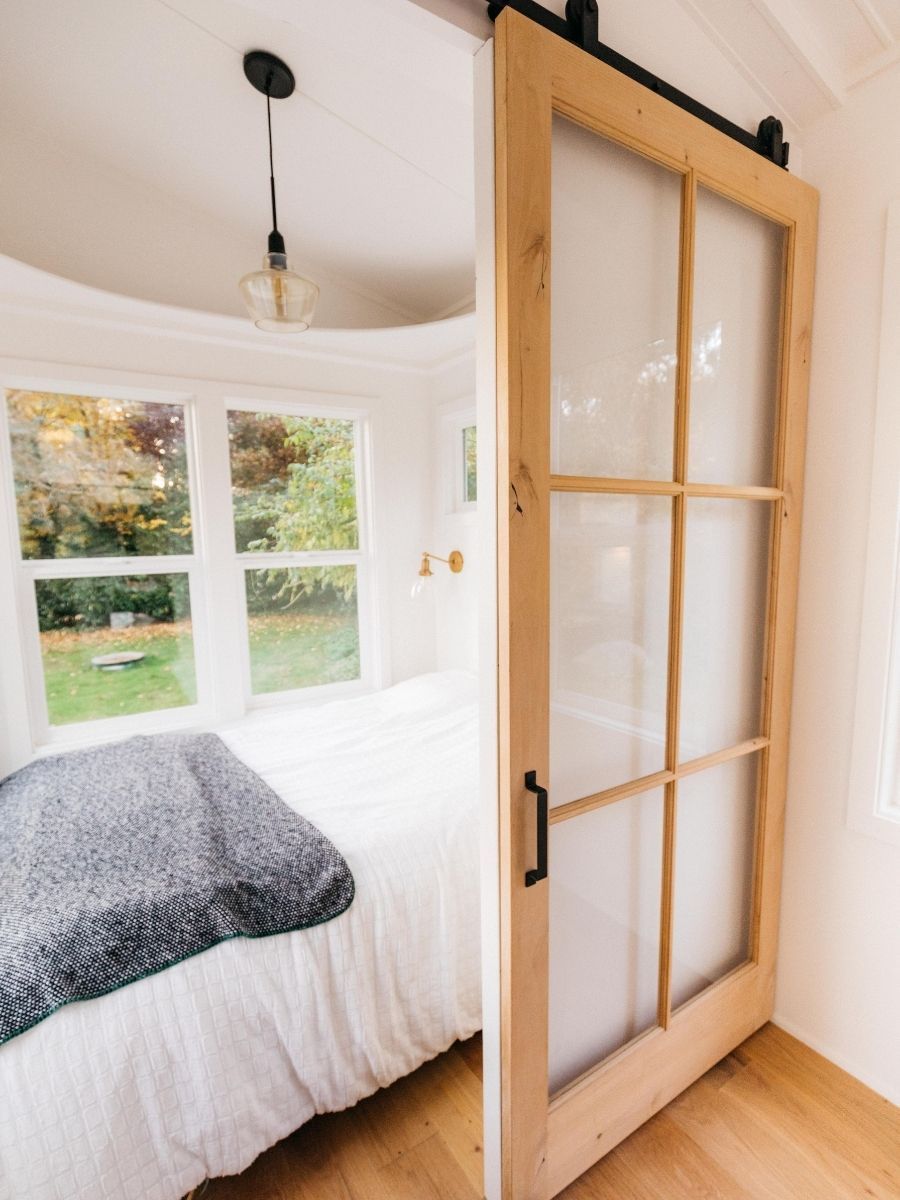 A bedroom with a bed and a sliding barn door