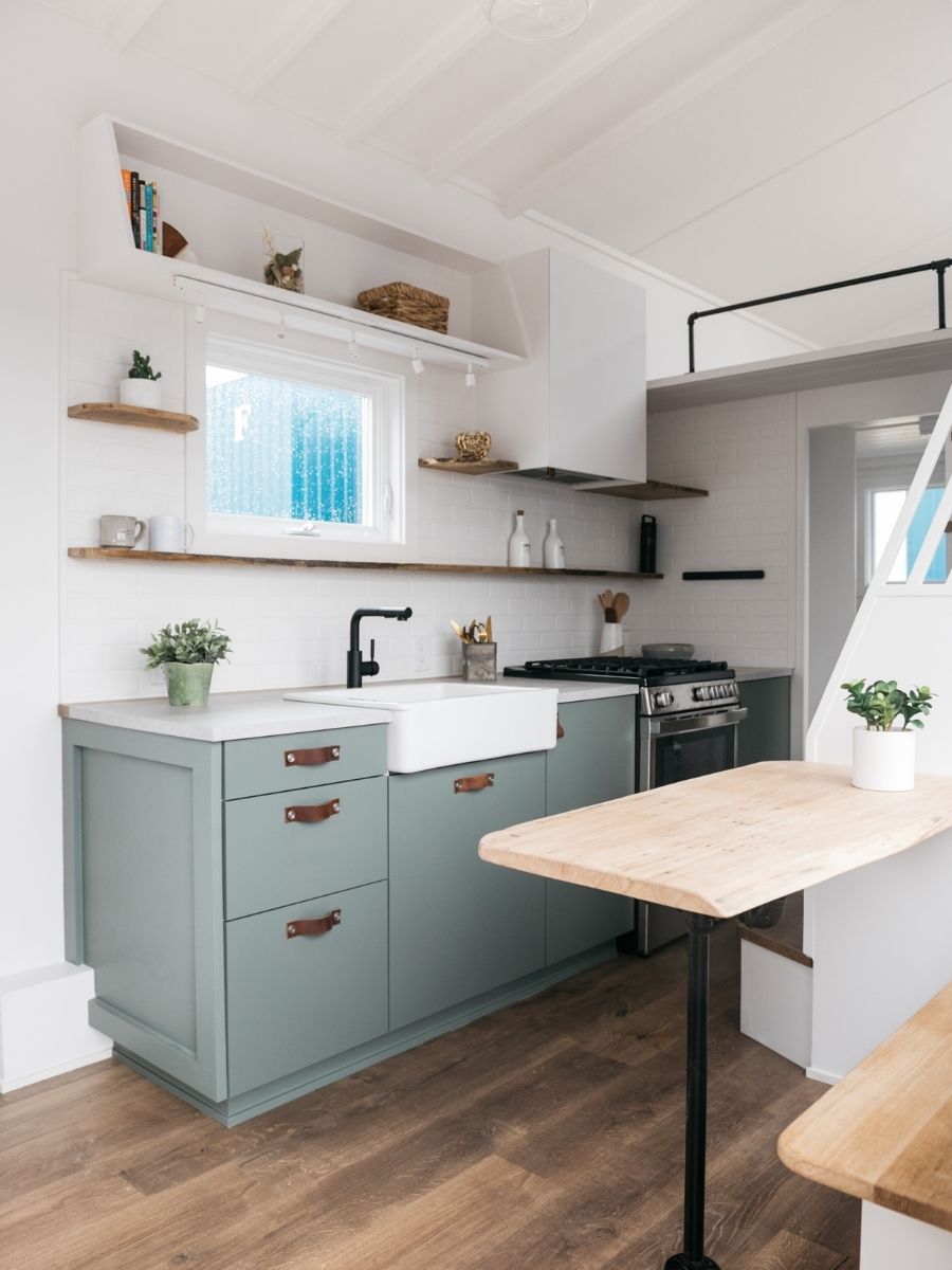 A kitchen with a sink , stove , and table.