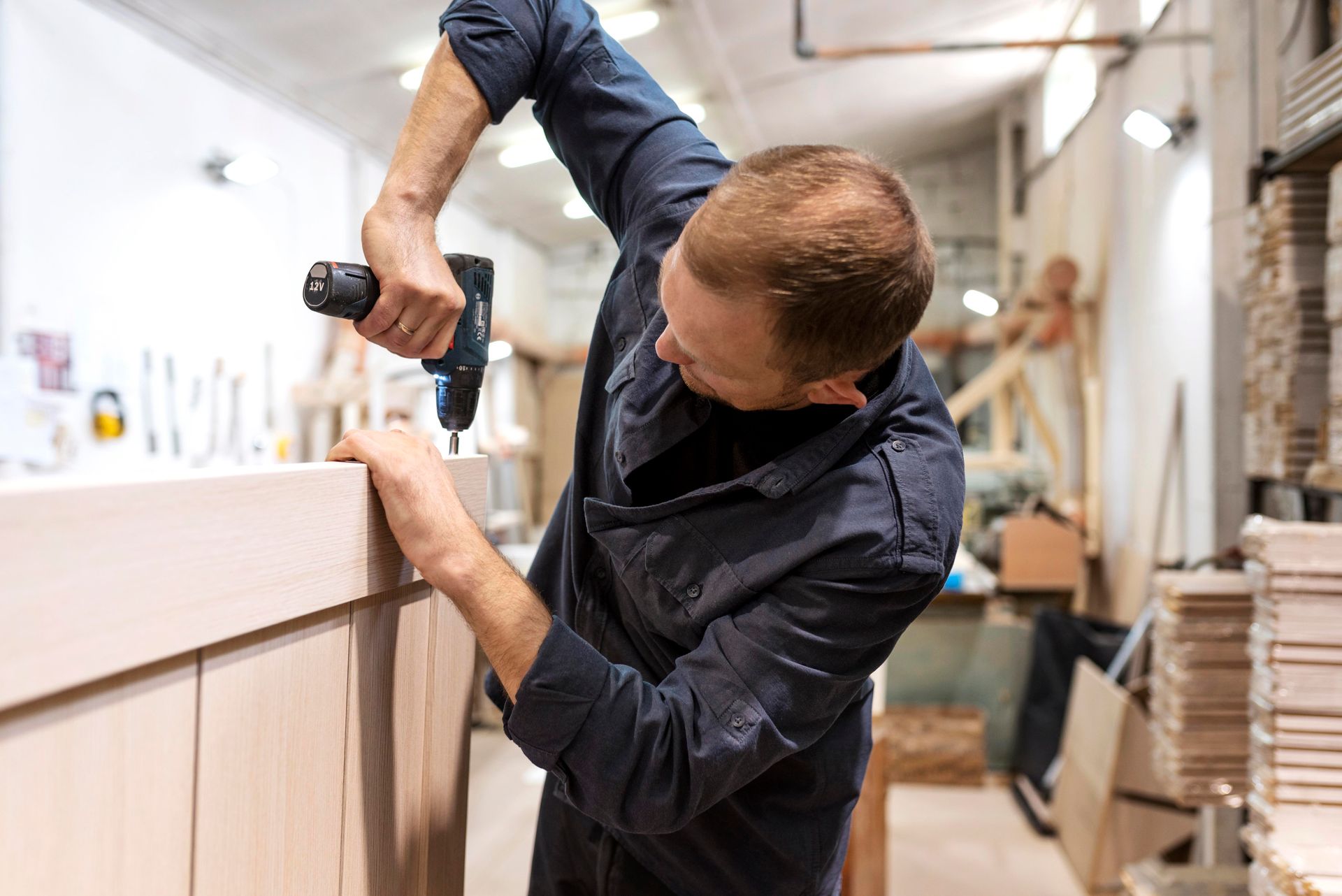 A plumber is fixing a sink in a kitchen.