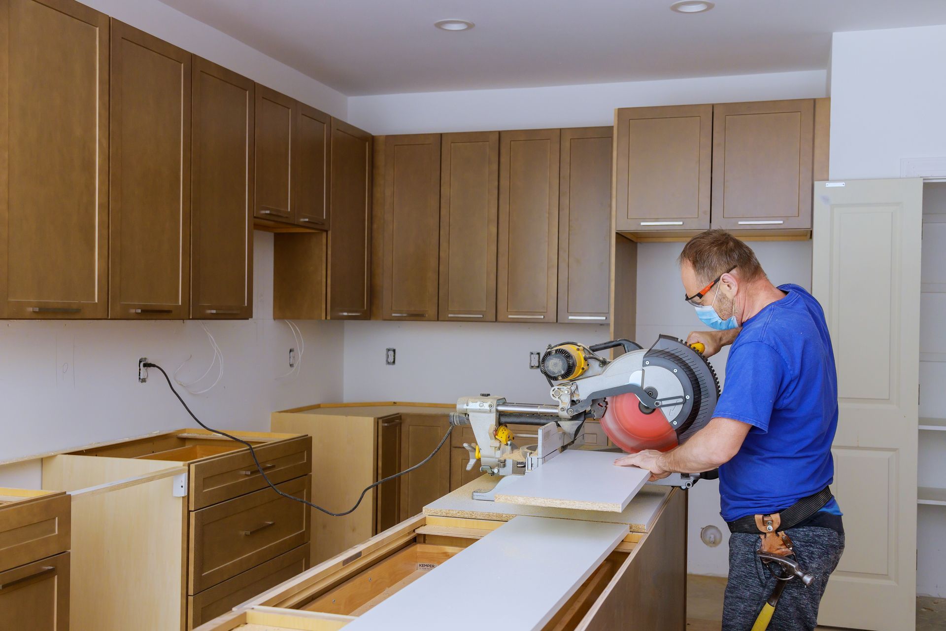 A plumber is fixing a sink in a kitchen.