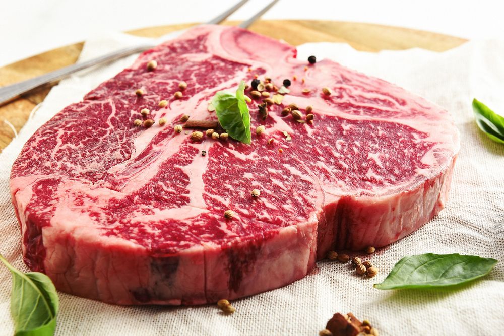 A Large Piece Of Raw Steak Is Sitting On A Napkin On A Cutting Board — McGrath Meats In Taree, NSW