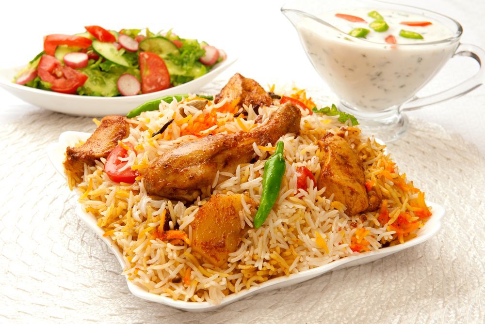 A Plate Of Chicken Biryani Next To A Bowl Of Salad — McGrath Meats In Taree, NSW