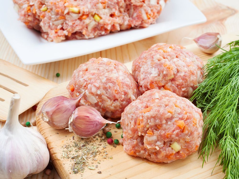 A Wooden Cutting Board Topped With Meatballs, Garlic And Dill — McGrath Meats In Taree, NSW
