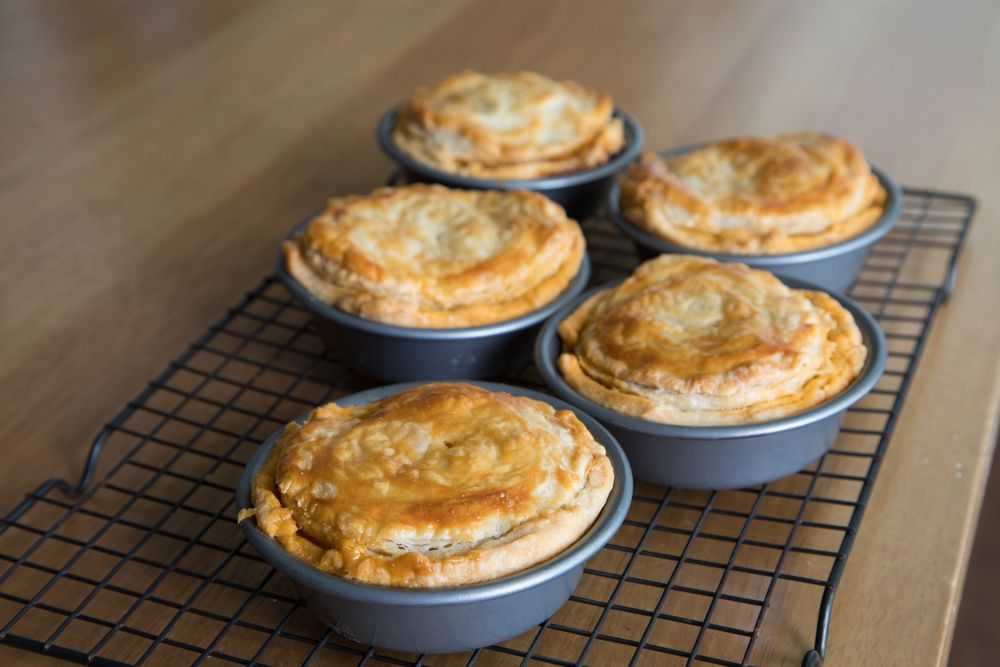 A Bunch Of Pies Are Sitting On A Cooling Rack On A Table — McGrath Meats In Taree, NSW