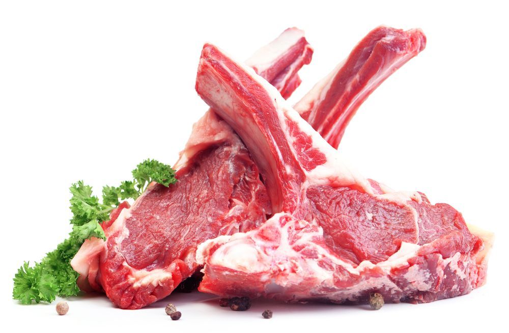 A Pile Of Raw Lamb Chops With Parsley And Pepper On A White Background — McGrath Meats In Taree, NSW