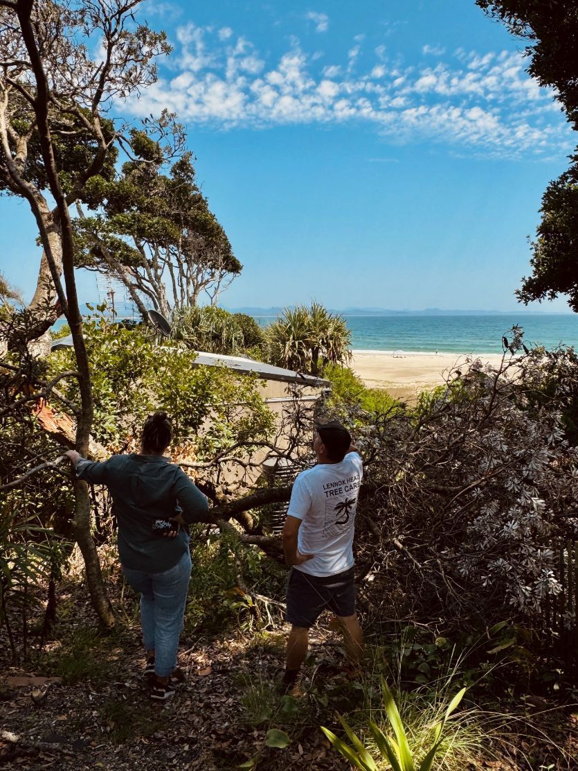 Two people are standing in the woods looking at the ocean — Lennox Head Tree Care In Lennox Head, NSW